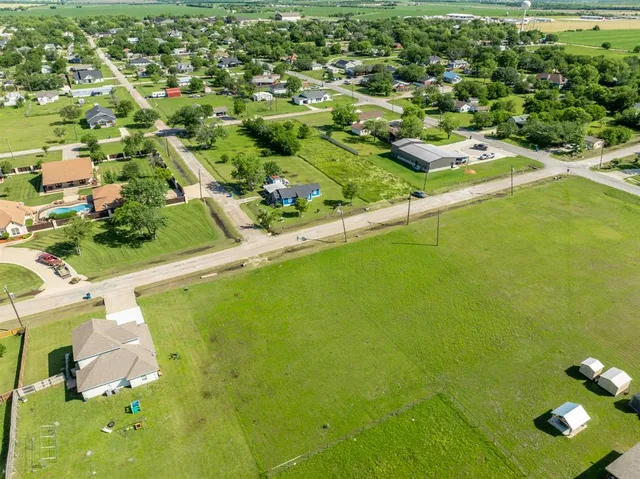 an aerial view of residential houses with outdoor space and trees