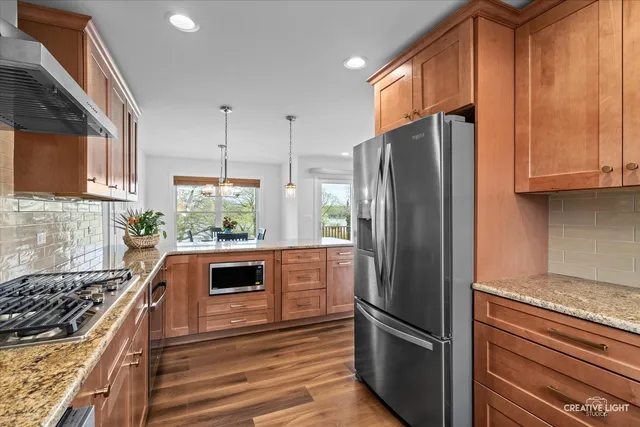 a kitchen with stainless steel appliances granite countertop a refrigerator and a stove