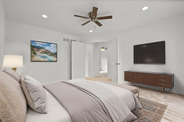 a bedroom with a bed a mirror and a flat screen tv