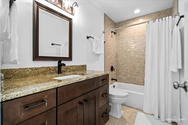 a bathroom with a granite countertop sink toilet and shower