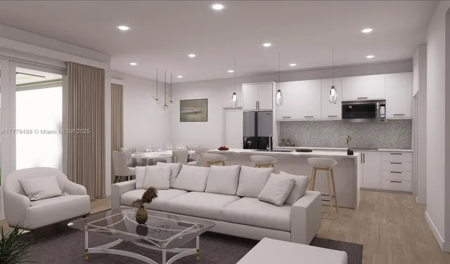 a living room with furniture a kitchen view and a window