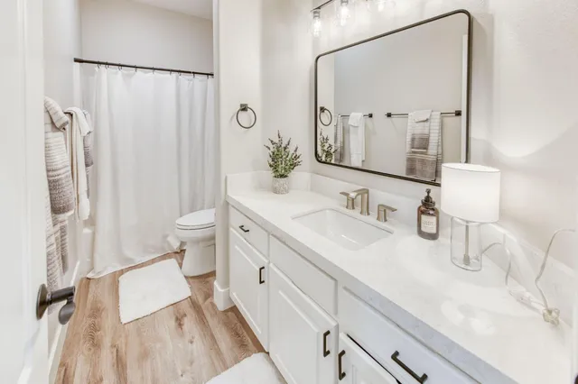 a bathroom with a granite countertop sink toilet and shower