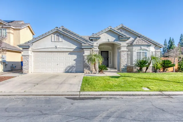 a front view of a house with a garden and plants