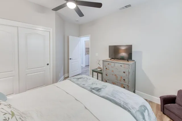 a bedroom with a bed and a flat tv screen on dresser