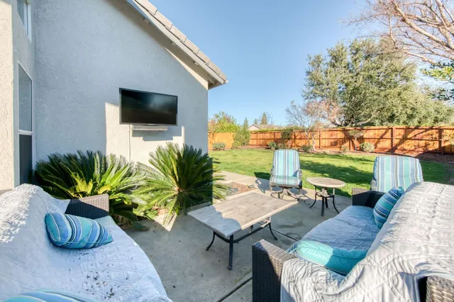 a living room with patio furniture and a potted plants