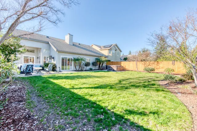 a view of house with garden and tall trees
