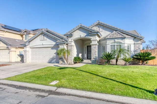 a front view of a house with a yard and garage