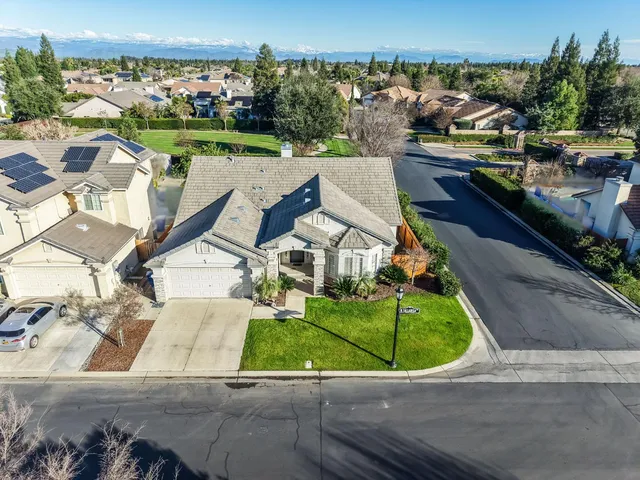 an aerial view of a house with a yard and lake view