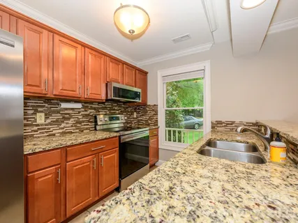 a kitchen with granite countertop a stove sink and microwave