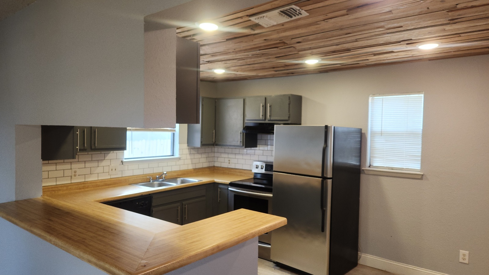2807 West Slaughter Lane, Unit B Austin, TX 78748 - Photo 9 of 12 Kitchen featuring stainless steel appliances, a peninsula, tasteful backsplash, light countertops, and wood ceiling