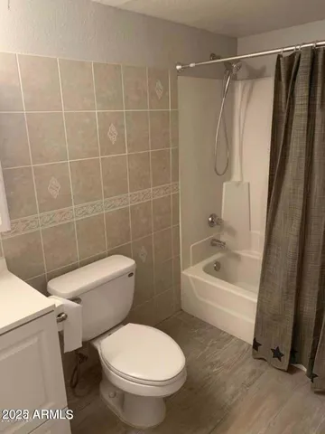 a white toilet sitting next to a bath tub and a shower