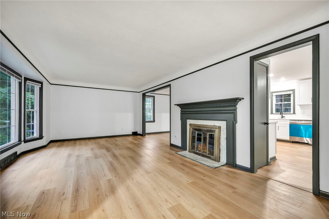 1352 Ford Road Lyndhurst, OH 44124 - Photo 15 of 48 Unfurnished living room featuring a high end fireplace, sink, and light hardwood / wood-style flooring