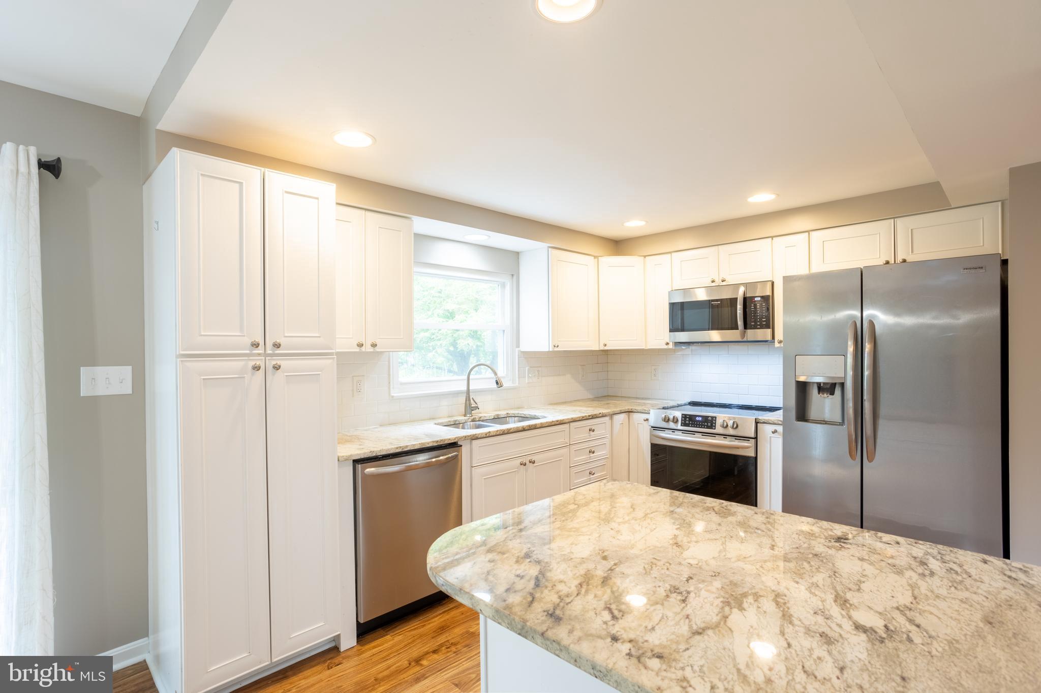 a kitchen with stainless steel appliances granite countertop a refrigerator sink and stove