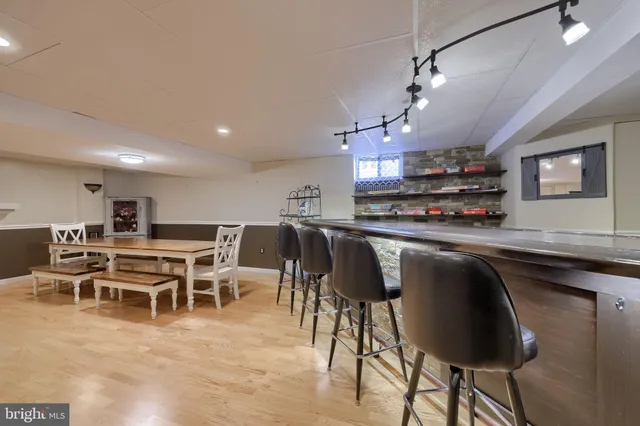 a kitchen with stainless steel appliances granite countertop a table chairs in it and wooden floors