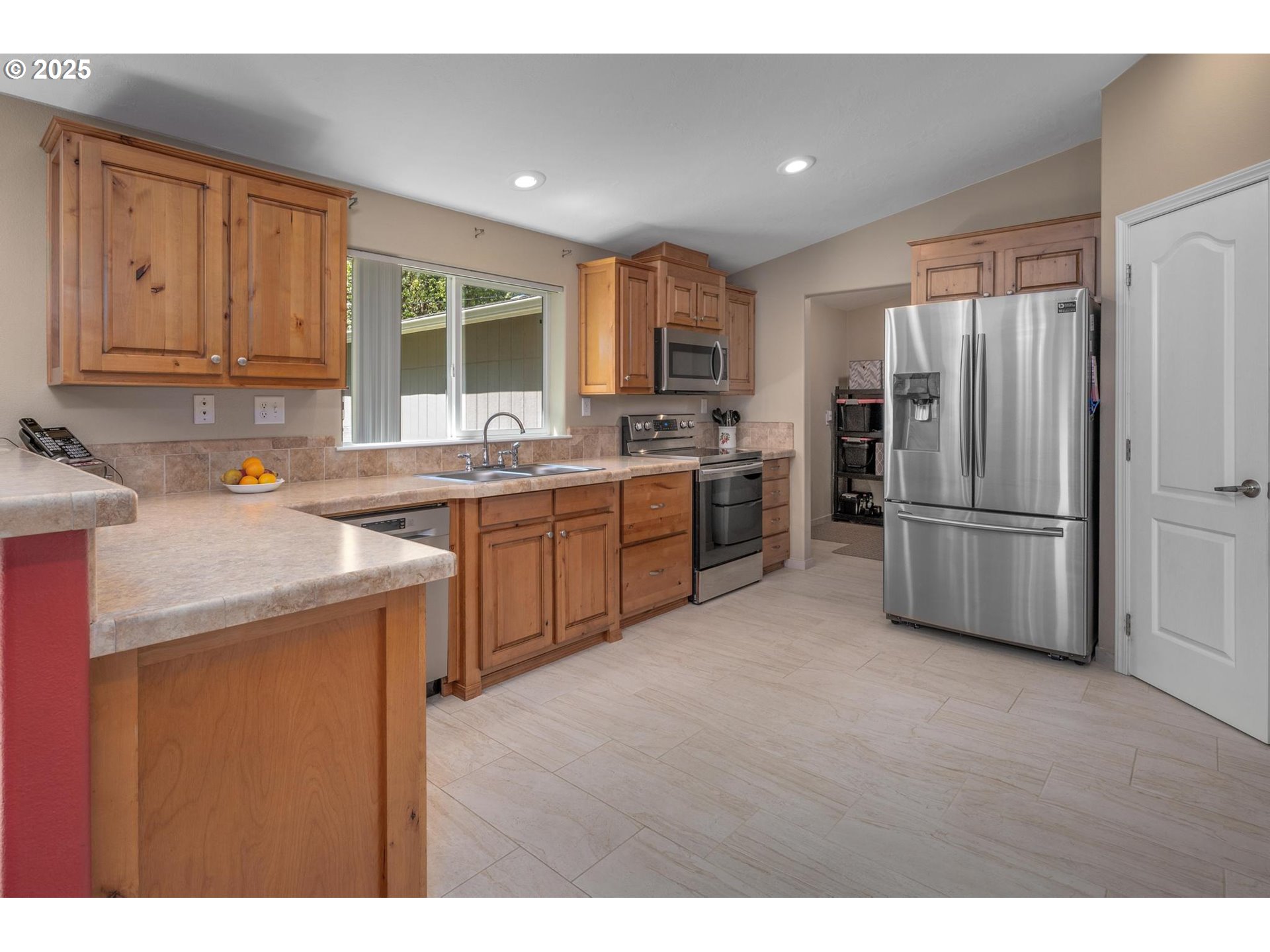 20270 Northwest Pihl Road Banks, OR 97106 - Photo 12 of 43 a kitchen with stainless steel appliances granite countertop a refrigerator a sink dishwasher a stove with wooden cabinets