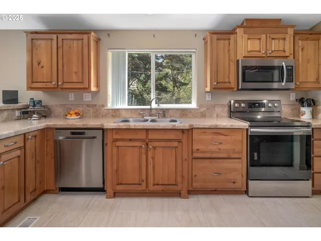 a kitchen with stainless steel appliances granite countertop a stove a sink and a microwave