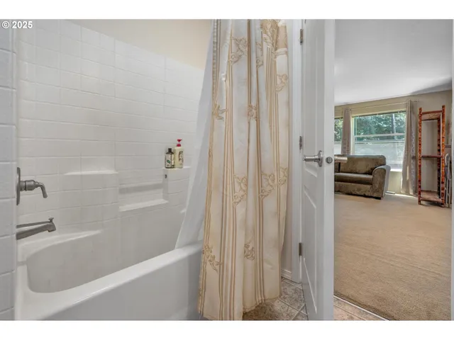 a bathroom with a tub a sink a mirror and a shower