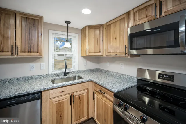 a kitchen with stainless steel appliances granite countertop a sink stove and microwave
