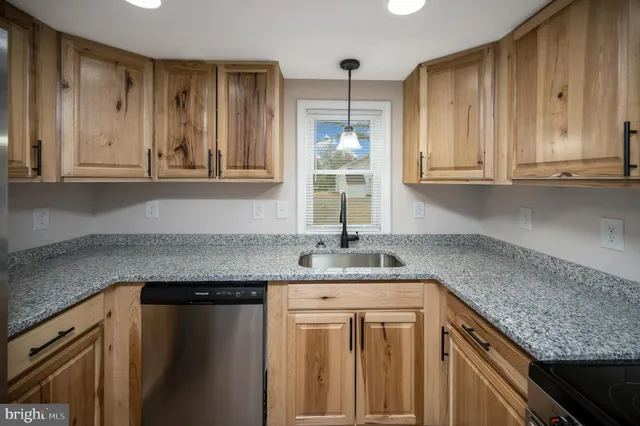 a kitchen with stainless steel appliances granite countertop a sink and dishwasher cabinets with wooden floor