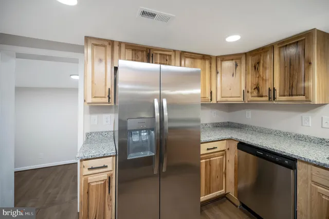 a kitchen with stainless steel appliances granite countertop a refrigerator and a sink