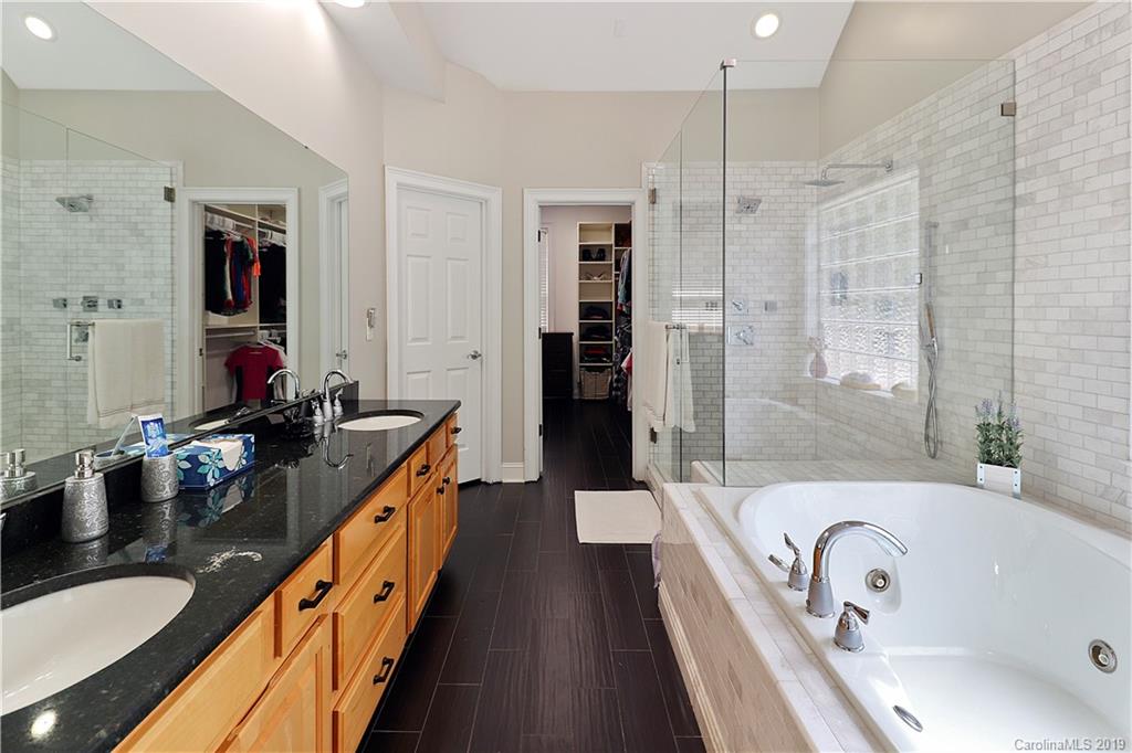 3458 Blue Jay Pass Fort Mill, SC 29708 - Photo 18 of 33 a bathroom with a granite countertop tub double vanity sink and a large mirror