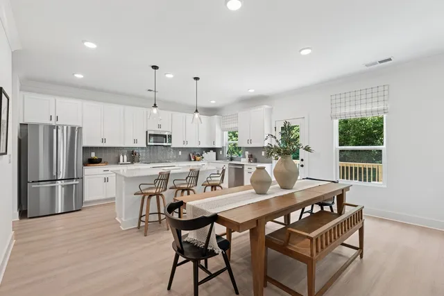 a kitchen with a table chairs refrigerator and microwave