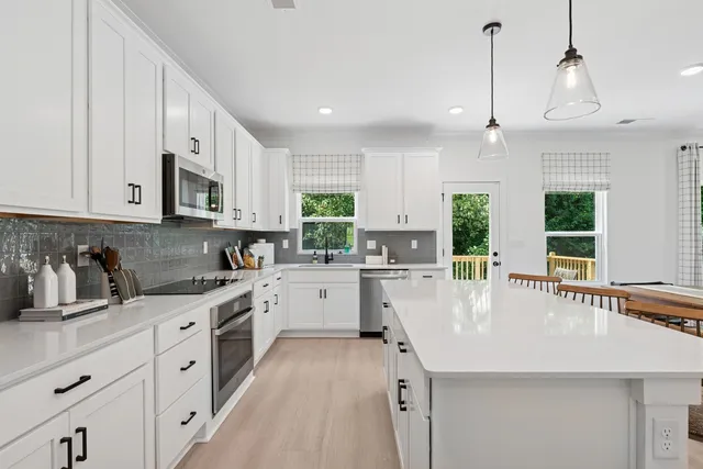 a kitchen with stainless steel appliances kitchen island granite countertop a sink a stove and cabinets