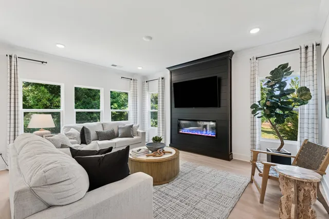 a living room with furniture a large window and a flat screen tv