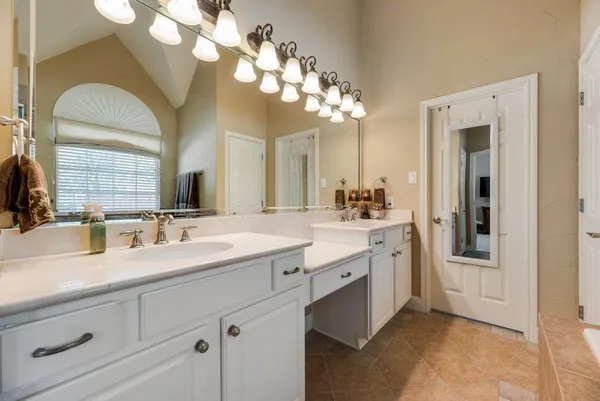 a spacious bathroom with a granite countertop sink a mirror and a shower
