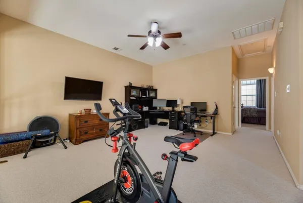 a room with gym equipment and a flat screen tv