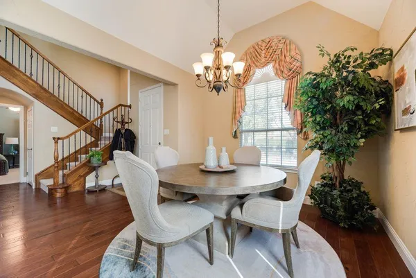 a view of a dining room with furniture wooden floor and chandelier