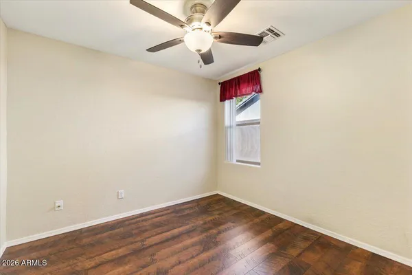 an empty room with a window and a fan