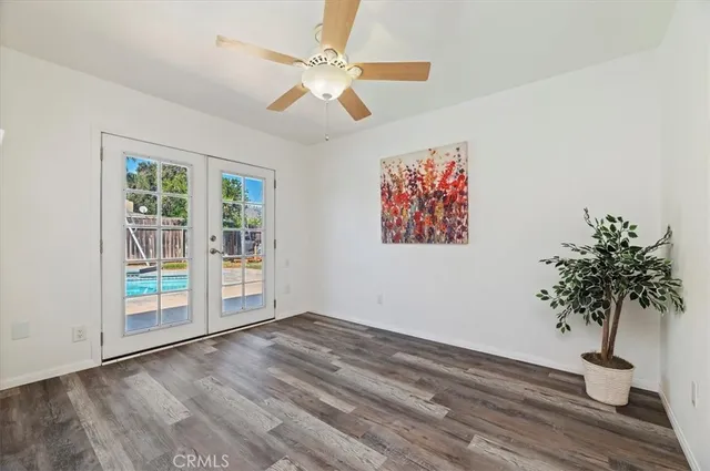 a view of a room with wooden floor and a ceiling fan