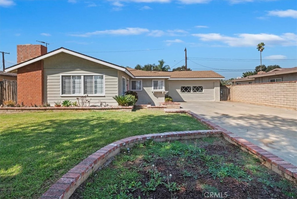 8797 Brunswick Avenue Riverside, CA 92503 - Photo 19 of 23 a front view of a house with a yard and potted plants