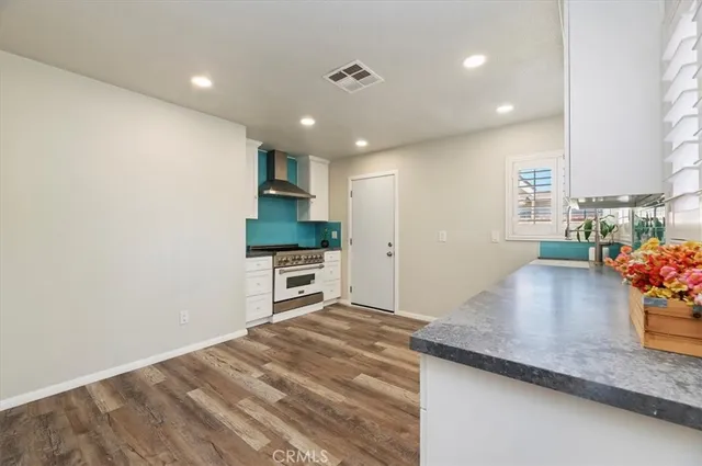 a kitchen with granite countertop a stove a sink and a refrigerator