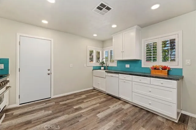 a kitchen with granite countertop white cabinets and white appliances