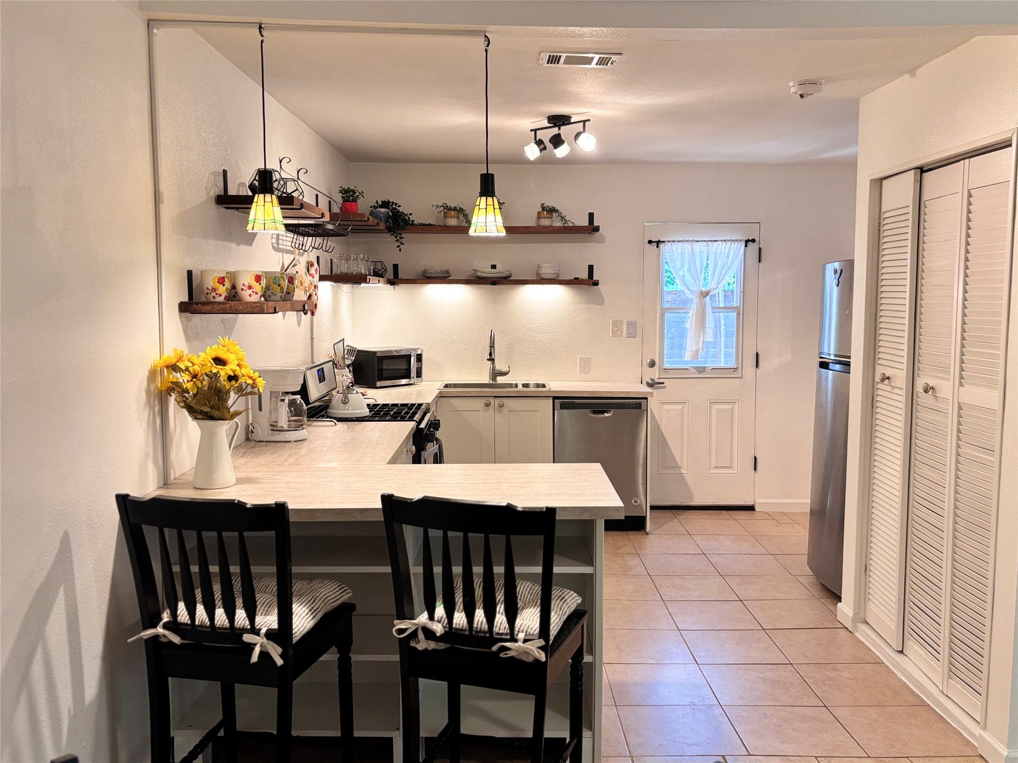 5414 Bolm Road, Unit B Austin, TX 78721 - Photo 3 of 8 A well-appointed kitchen features open shelving, stainless steel appliances, and a convenient breakfast bar.