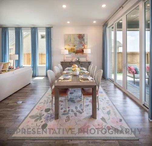 a living room with furniture a large window and wooden floor