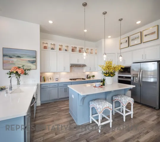 a kitchen with granite countertop a table chairs stove and refrigerator