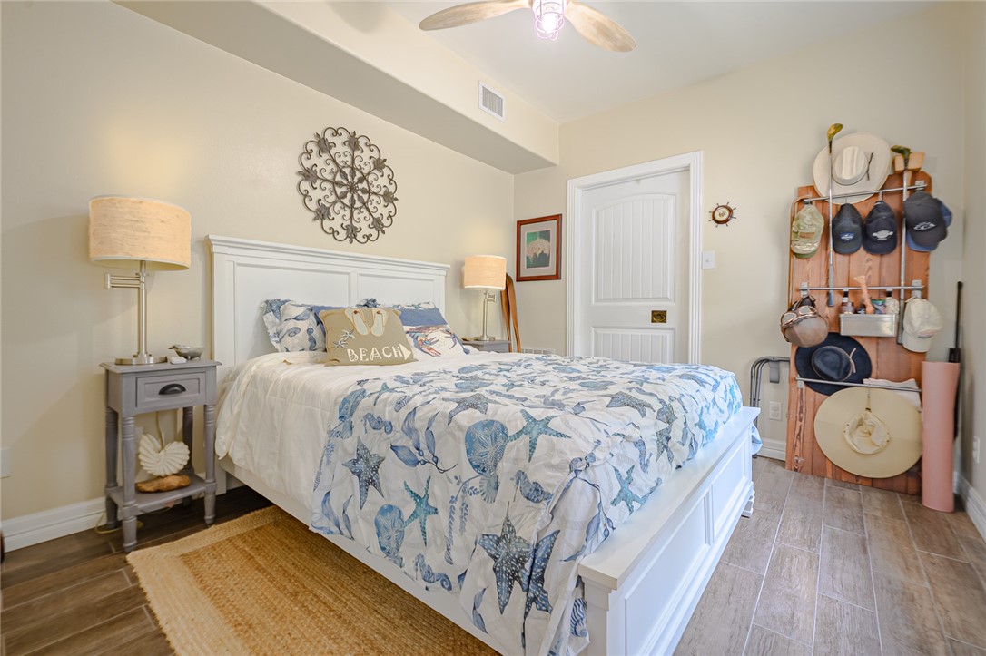 102 South 7th Street Fulton, TX 78358 - Photo 16 of 40 a bedroom with a large bed and a lamp on dresser