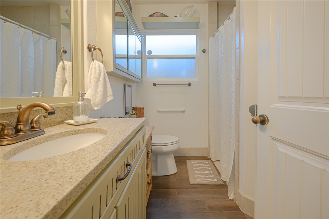 102 South 7th Street Fulton, TX 78358 - Photo 17 of 40 a bathroom with a granite countertop sink a toilet and a mirror