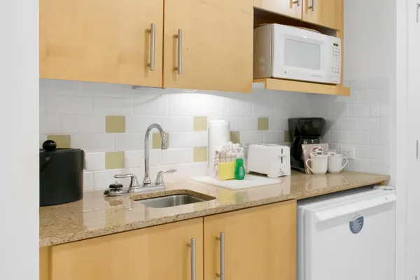 a view of a kitchen with fridge and wooden floor