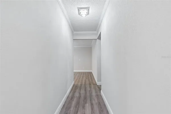 a kitchen with white cabinets stainless steel appliances a sink and wooden floor