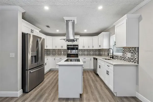a kitchen with granite countertop a sink and a stove