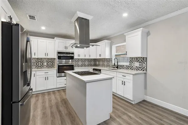 a kitchen with a refrigerator and white cabinets