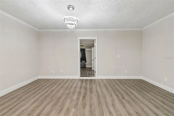 an empty room with wooden floor and ceiling fan