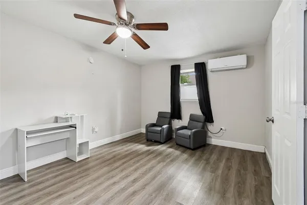 an empty room with wooden floor and ceiling fan