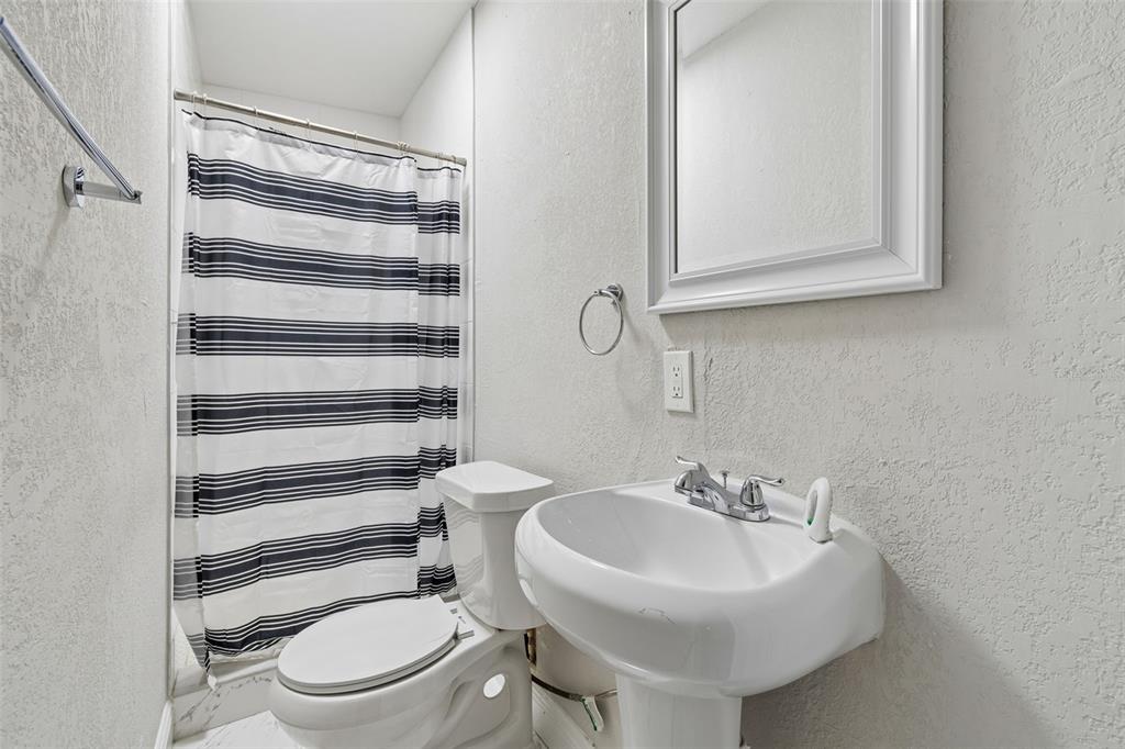 7403 Spring Court Tampa, FL 33634 - Photo 39 of 100 a bathroom with a toilet a sink and a mirror