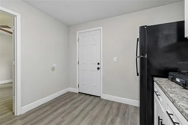 a living room with furniture kitchen view and a large window