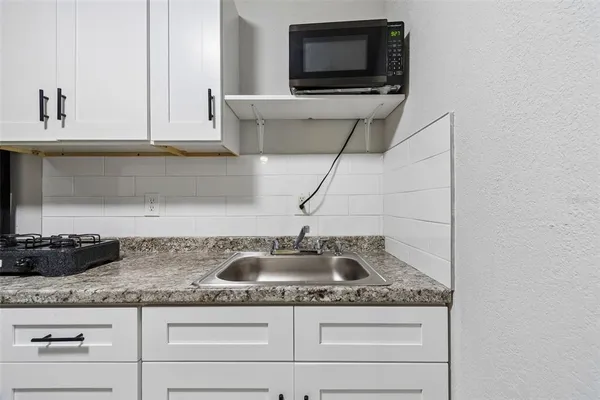 a large white kitchen with stainless steel appliances